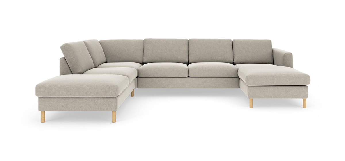 Lys beige modulær hjørnesofa med chaiselong i begge ender, stofbetræk og lyse træben, frilagt på hvid baggrund.