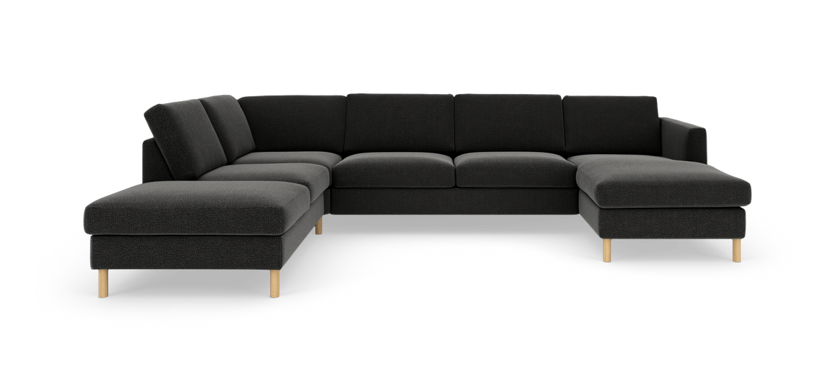 Mørkegrå U‑sofa i stof med træben, frilagt på hvid baggrund.