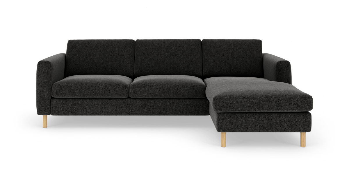 Mørkegrå hjørnesofa med højrevendt chaiselong og lyse træben, frilagt på hvid baggrund.