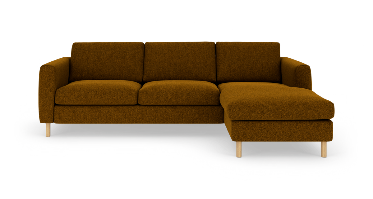 Brun hjørnesofa med chaiselong til højre på lyse træben, isoleret mod hvid baggrund.