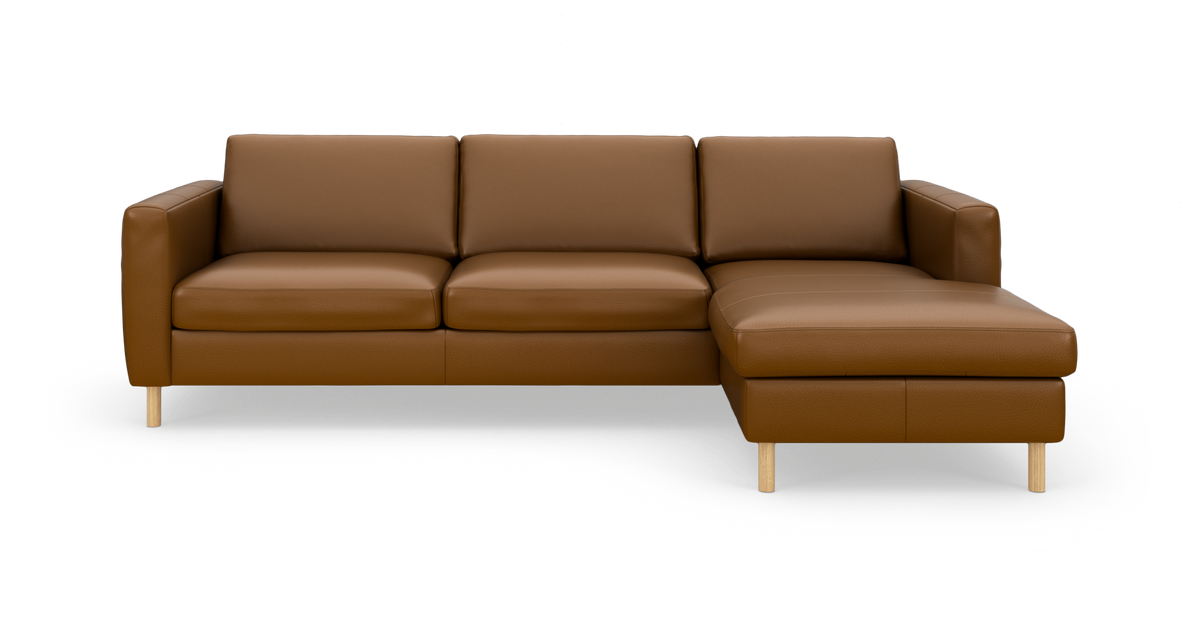 Brun læderhjørnesofa med chaiselong til højre og lyse træben, frilagt på hvid baggrund.
