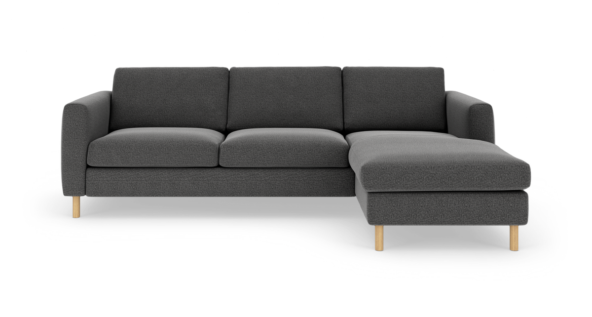 Mørkegrå hjørnesofa med højrevendt chaiselong og lyse træben, frilagt på hvid baggrund.