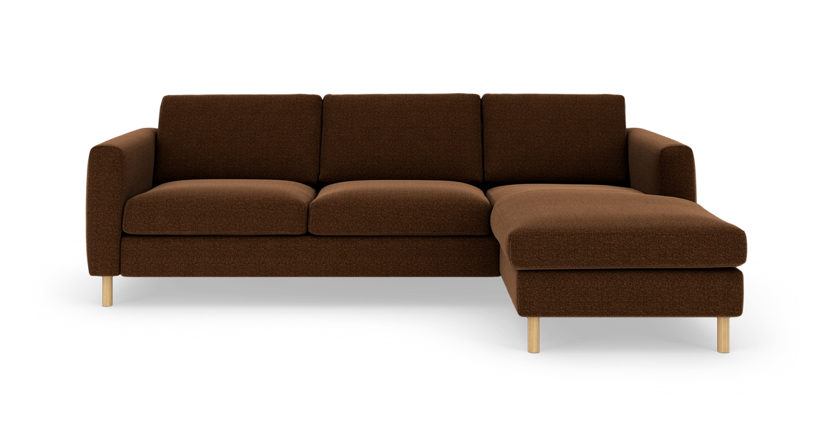 Brun hjørnesofa med chaiselong til højre på hvid baggrund med træben.