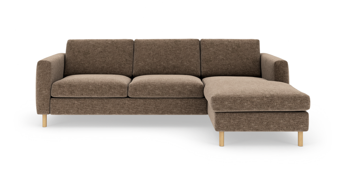Brun hjørnesofa med chaiselong til højre, træben og bløde hynder.