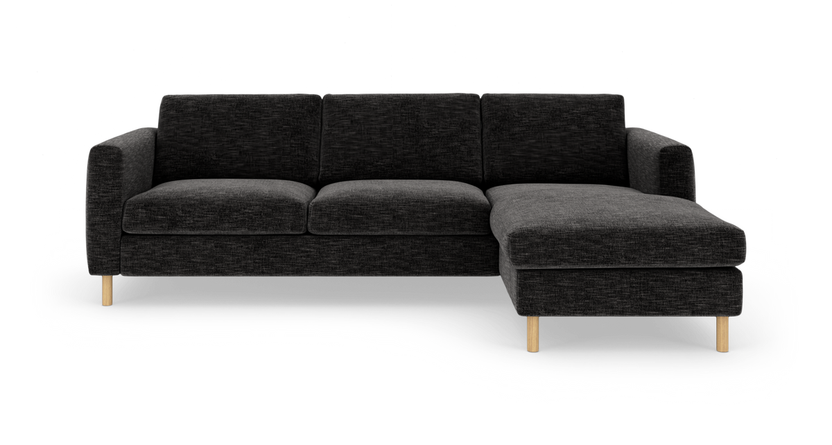 Mørkegrå hjørnesofa med chaiselong til højre, lige armlæn og lyse træben, fritlagt på hvid baggrund.