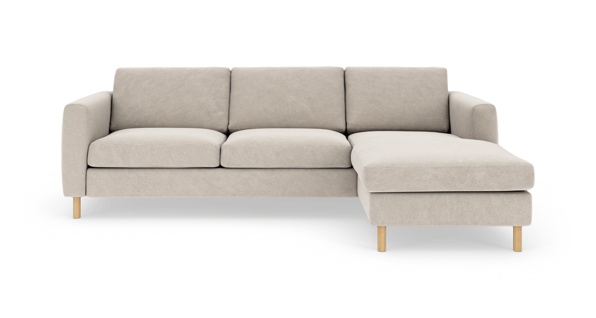 Beige modulsofa med højre chaiselong, lige armlæn og lyse træben, frilagt på hvid baggrund.