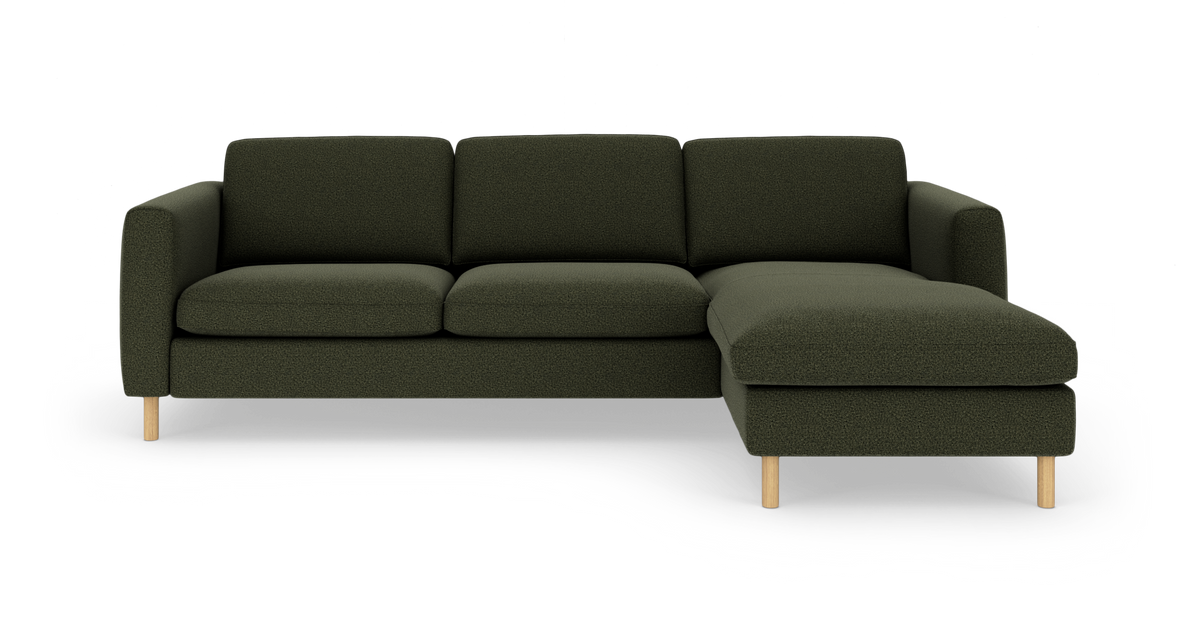 Mørkegrøn hjørnesofa med højre chaiselong og lyse træben, fritlagt mod hvid baggrund.