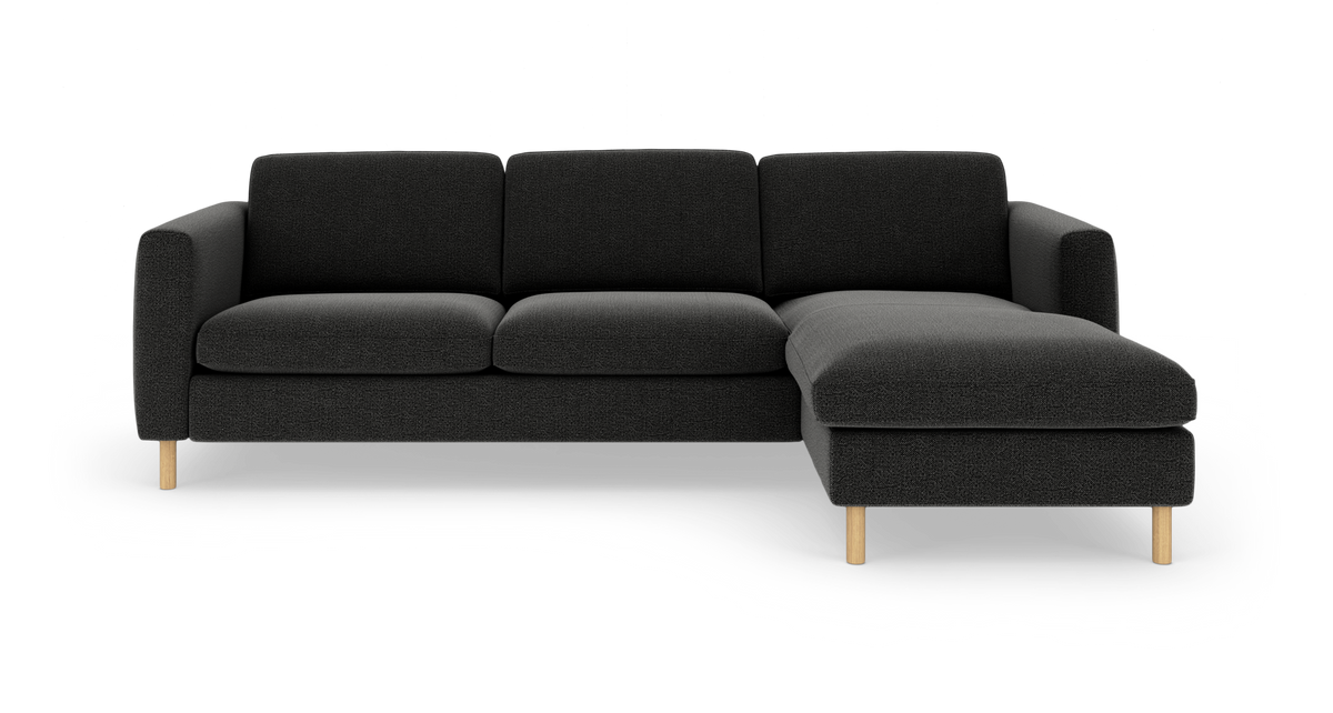 Sort modulsofa med højre chaiselong, stofpolstring og lyse træben, frilagt på hvid baggrund.