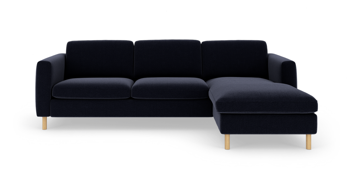 Mørkeblå hjørnesofa med chaiselong på højre side, fritlagt på hvid baggrund.