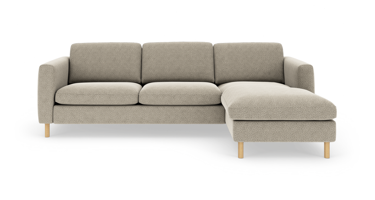 Beige modulsofa med højrevendt chaiselong, bløde armlæn og lyse træben, frilagt på hvid baggrund.