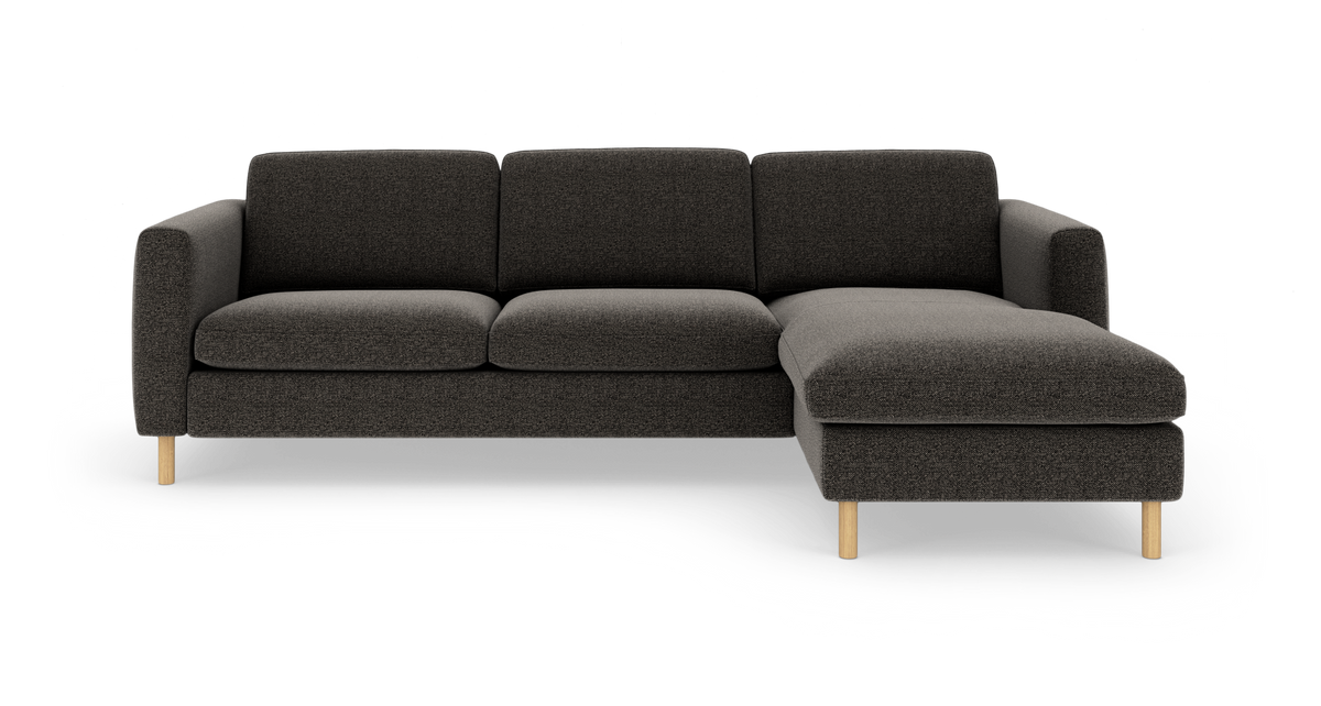 Mørkegrå hjørnesofa med chaiselong til højre på hvid baggrund.