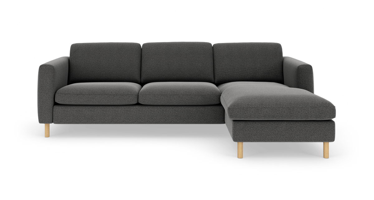 Mørkegrå hjørnesofa med højre chaiselong og lyse træben, set forfra på hvid baggrund.