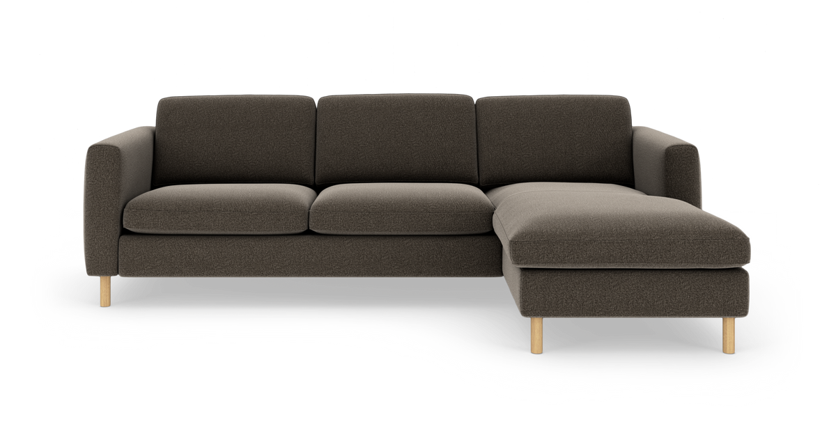 Mørkegrå 3-personers sofa med højre chaiselong og lyse træben, frilagt på hvid baggrund, set forfra.