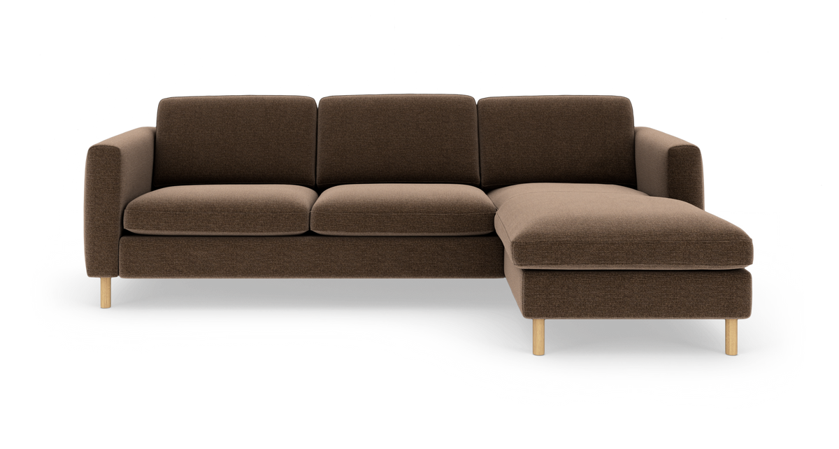 Brun 3-personers sofa med højrevendt chaiselong i stof og lyse træben, frilagt på hvid baggrund.