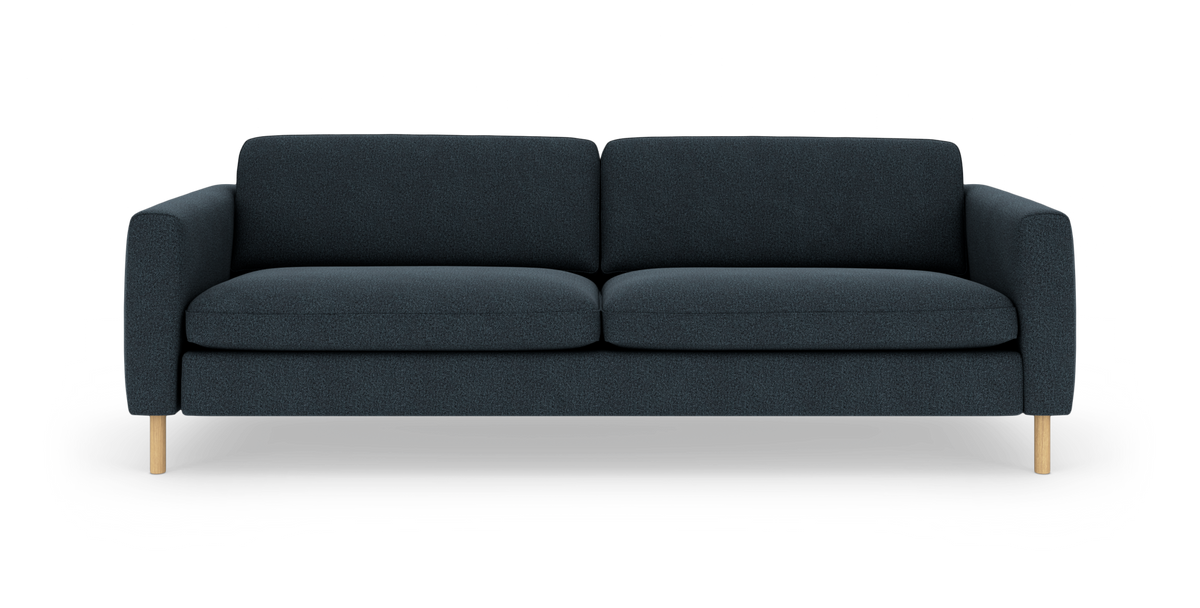 Mørkeblå tresæders sofa med afrundede armlæn og lyse træben, fotograferet forfra på hvid baggrund.