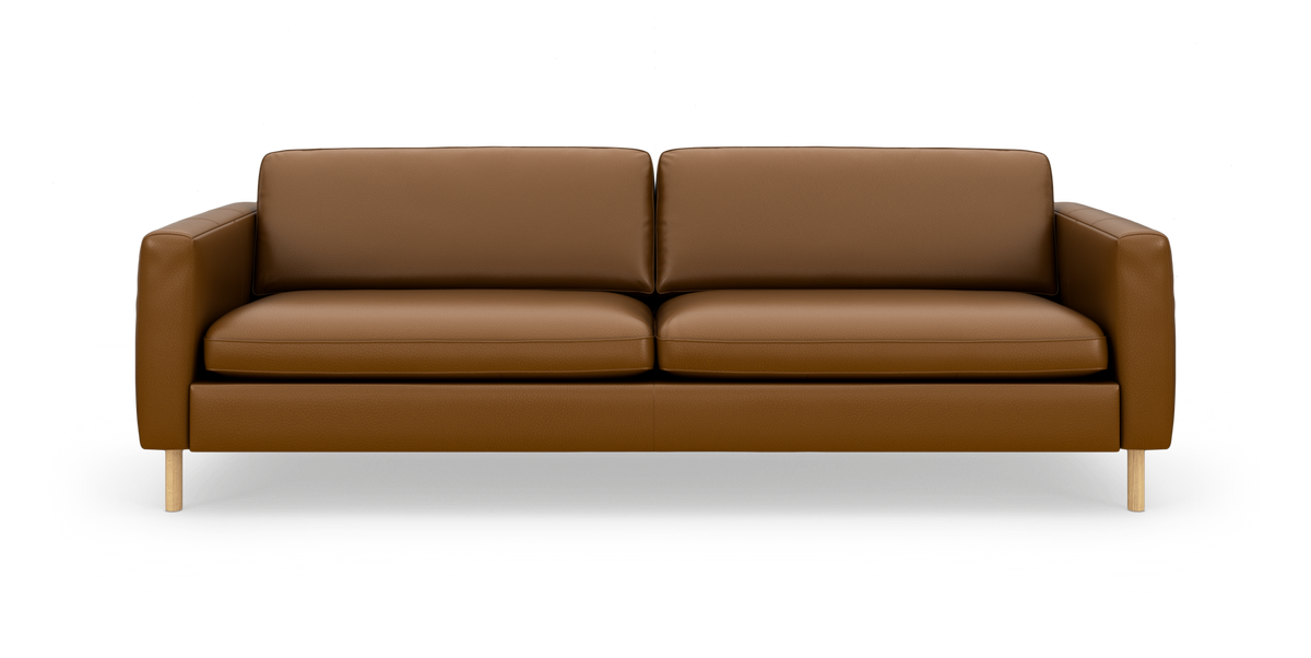 Brun lædersofa med træben, set forfra mod hvid studiobaggrund.