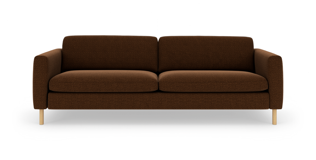 Brun stofsofa med afrundede armlæn og lyse træben, frilagt på hvid baggrund.