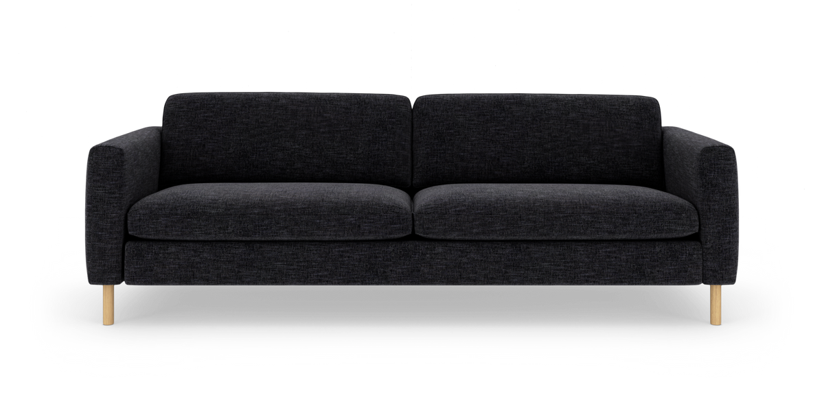 Sort stofsofa med træben, frilagt på hvid baggrund.