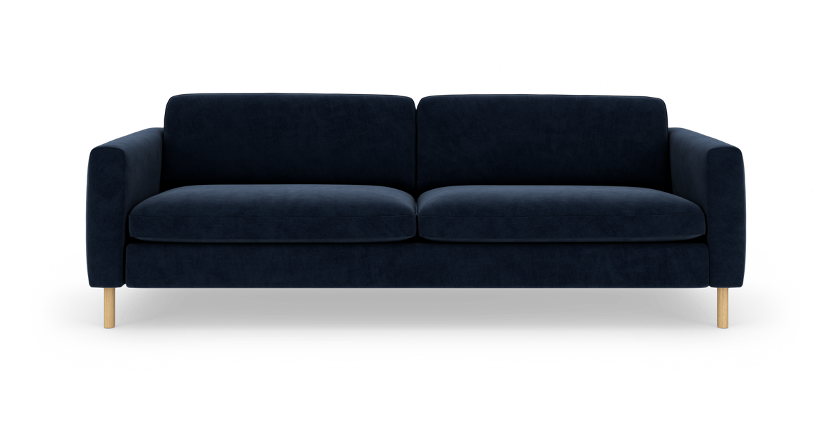 Mørkeblå 3-personers sofa med bløde, lige armlæn og lyse træben, fotograferet forfra på hvid baggrund.