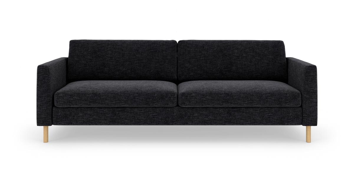 Mørkegrå sofa med lige armlæn og lyse træben, fotograferet lige for i studie.