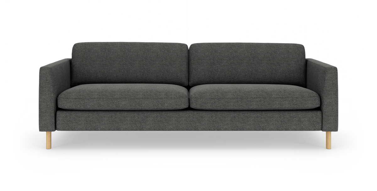 Mørkegrå 3-personers sofa med lige armlæn og lyse trieben, set forfra.