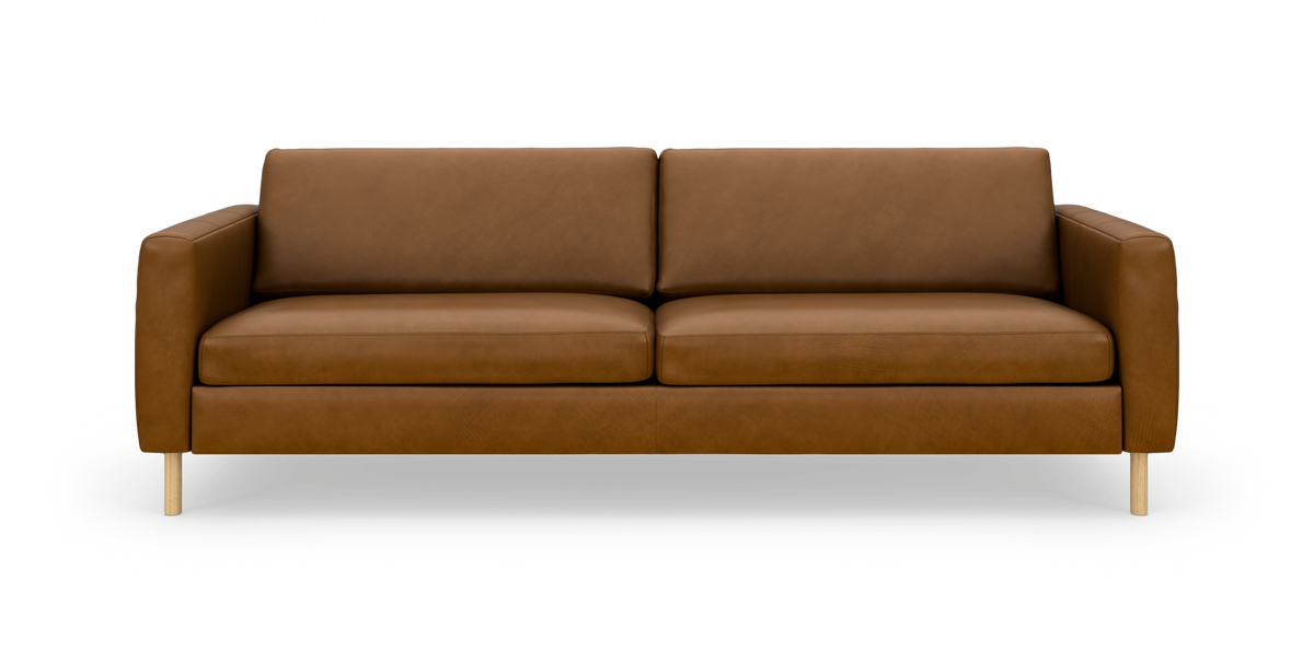 Brun lædersofa med træben set forfra i studie på hvid baggrund.