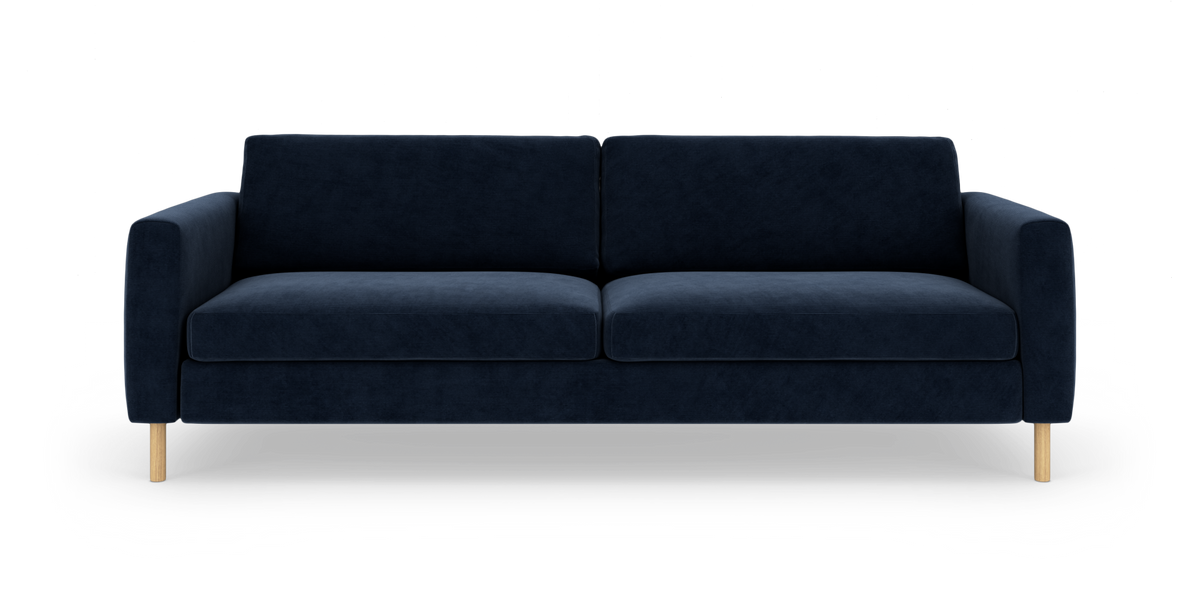 Mørkeblå tresæders sofa med træben, fotograferet forfra på hvid baggrund.