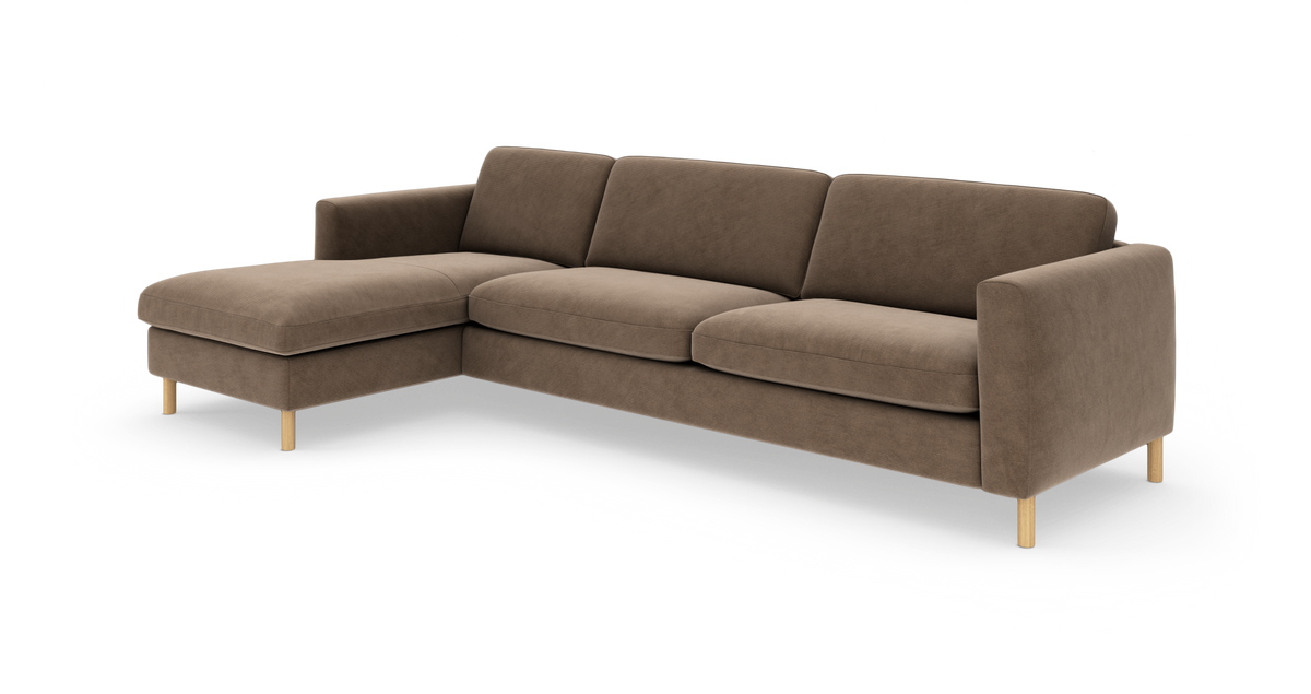 Brun hjørnesofa med venstrevendt chaiselong, bløde puder og lyse træben, fotograferet i studie.