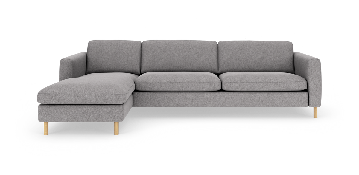 Grå hjørnesofa med venstrevendt chaiselong og lyse træben, set forfra.