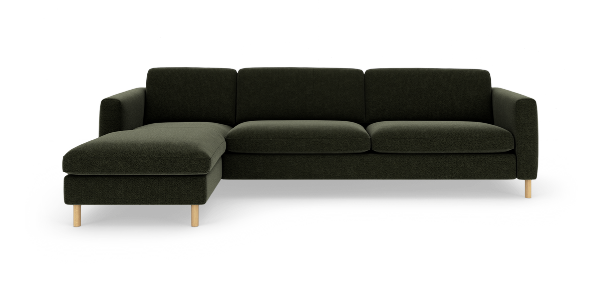 Modulsofa med venstrevendt chaiselong i mørkegrønt stof og runde træben, set forfra i studie.