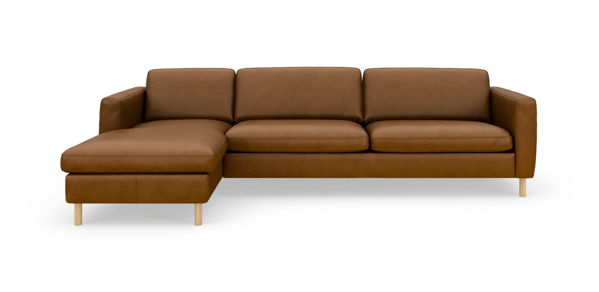 Brun læderhjørnesofa med venstre chaiselong på slanke træben, set forfra i studie.