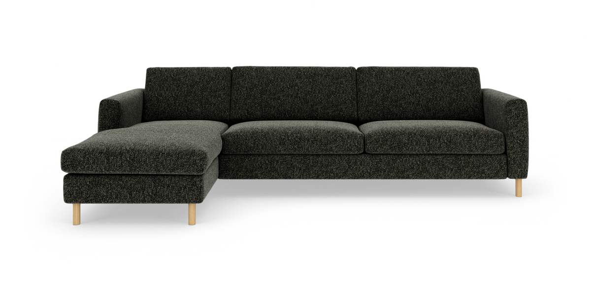 Mørkegrå L‑formet 4‑personers sofa med venstre chaiselong og runde træben, frilagt på hvid baggrund.