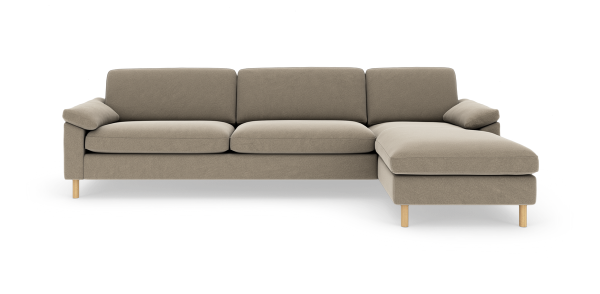 Beigefarvet 3-personers sofa med højrevendt chaiselong, slanke træben og bløde puder i moderne, minimalistisk design.