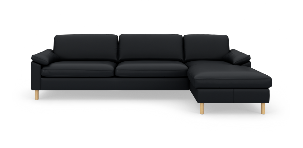 Sort modulsofa med højrevendt chaiselong, træben og rene linjer på hvid studiobaggrund.