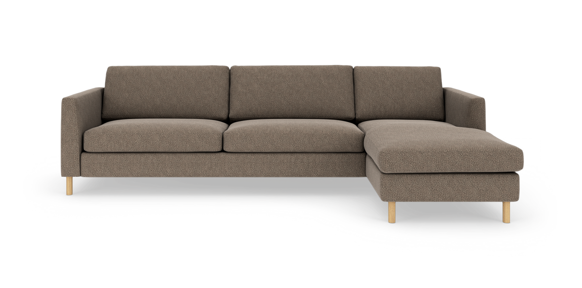 Brungrå hjørnesofa med chaiselong til højre, træben og minimalistisk design, frilagt på hvid baggrund.