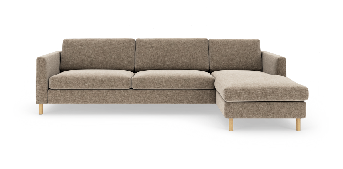Beige modulsofa med højrevendt chaiselong på lys baggrund, træben og tre siddepuder.
