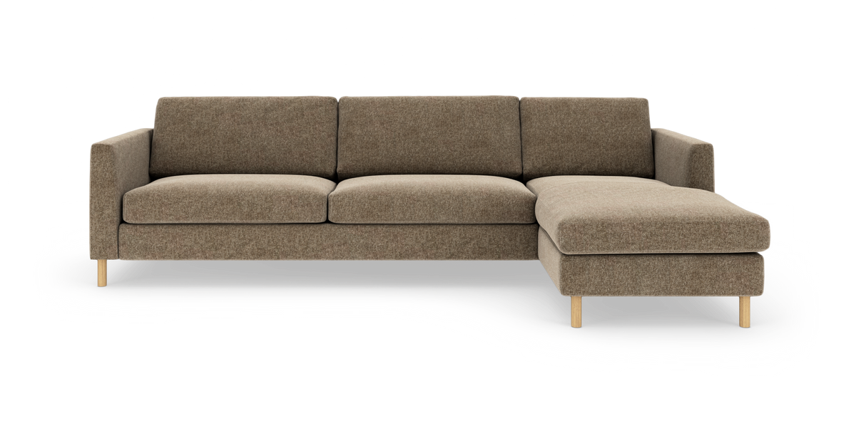 Brun hjørnesofa med chaiselong til højre og træben, fritstående på hvid baggrund.