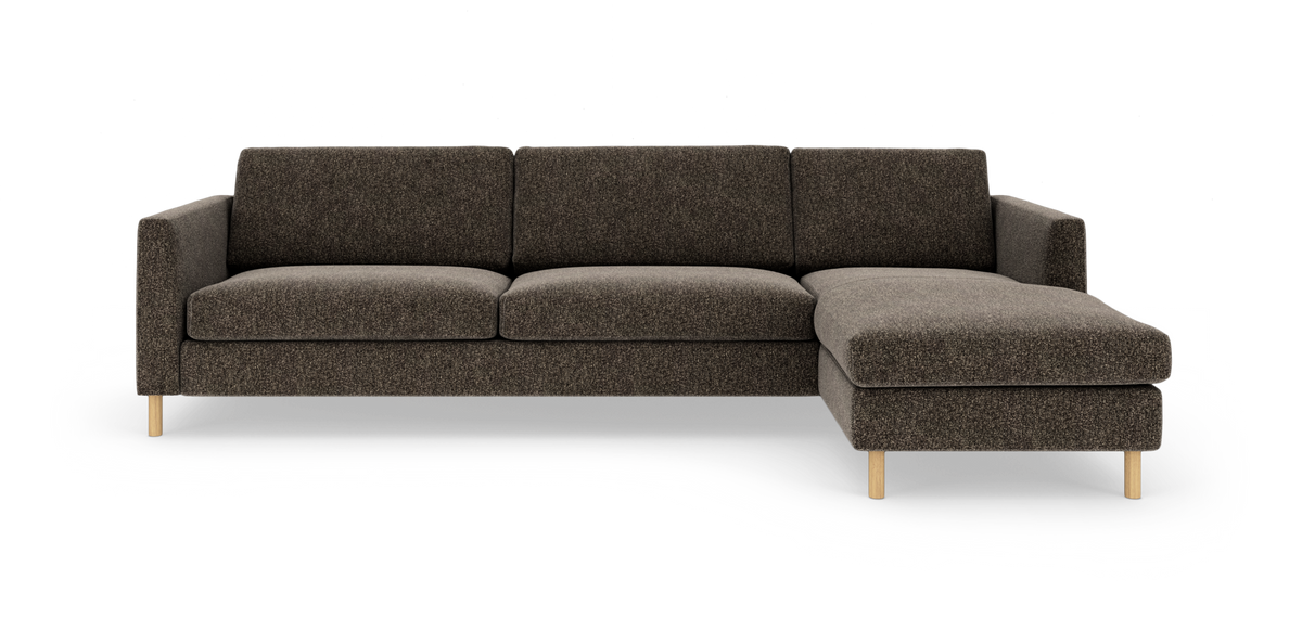 Mørkebrun hjørnesofa med chaiselong til højre og træben, frilagt på hvid baggrund.