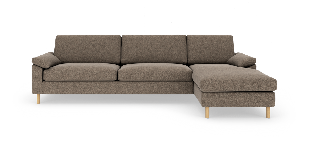 Modulsofa med højre chaiselong i beige stof og lyse træben, fotograferet forfra på hvid baggrund.