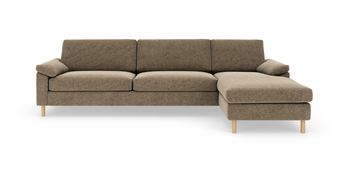Brun hjørnesofa med chaiselong til højre på hvid baggrund, træben, tre sæder og bløde hynder.