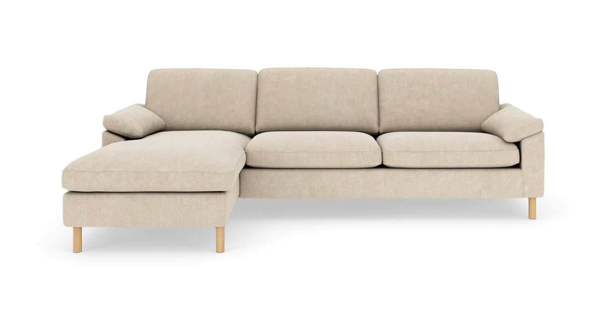 Beige hjørnesofa med chaiselong til venstre, lyse træben, tre sædehynder og bløde armlæn.
