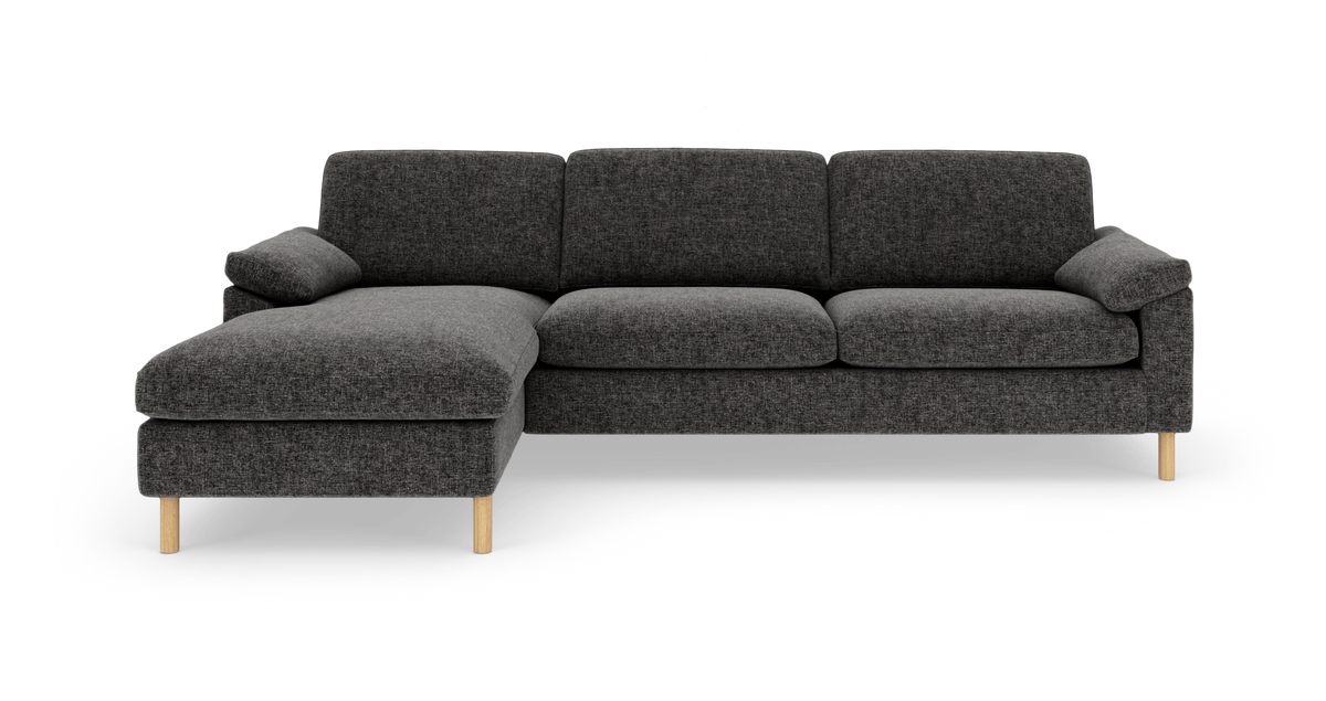 Mørkegrå hjørnesofa med venstre chaiselong og lyse træben, fritlagt på hvid baggrund.