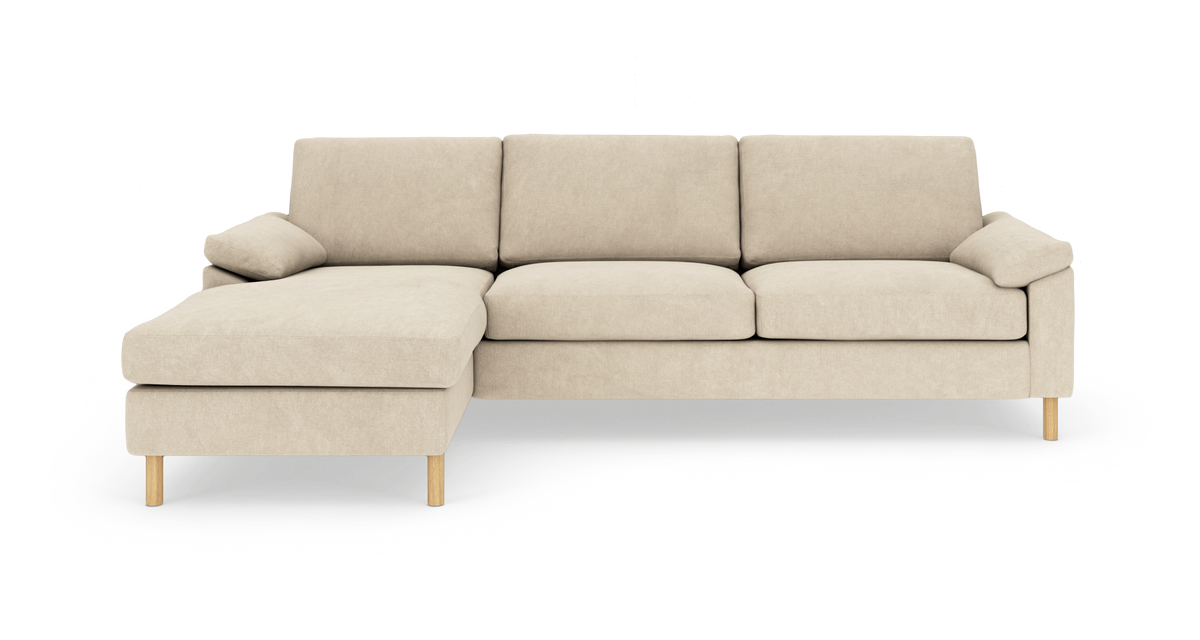 Beige hjørnesofa med venstrevendt chaiselong på træben, fritlagt på hvid baggrund.