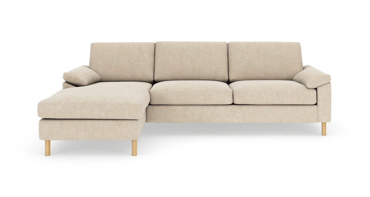 Beige hjørnesofa med venstre chaiselong og træben, fotograferet lige forfra mod hvid baggrund.