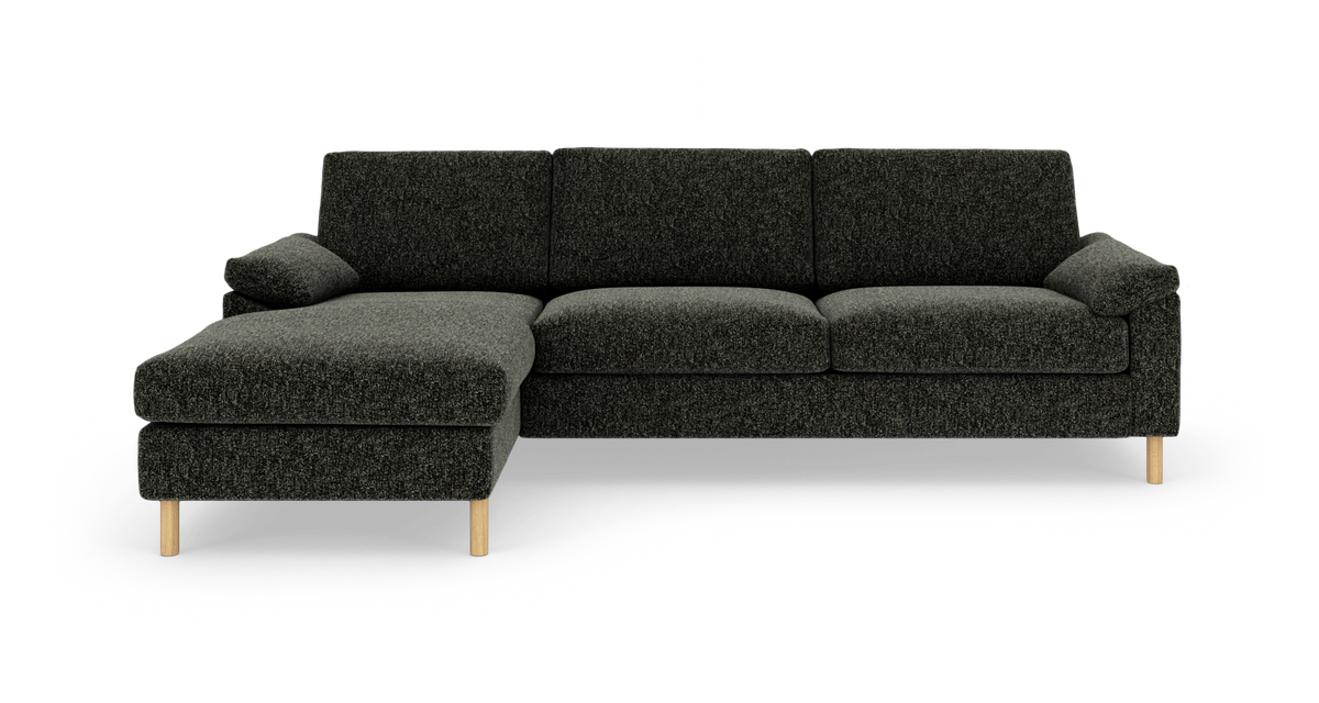 Mørkegrå hjørnesofa med venstrevendt chaiselong og lyse træben, frilagt på hvid baggrund.