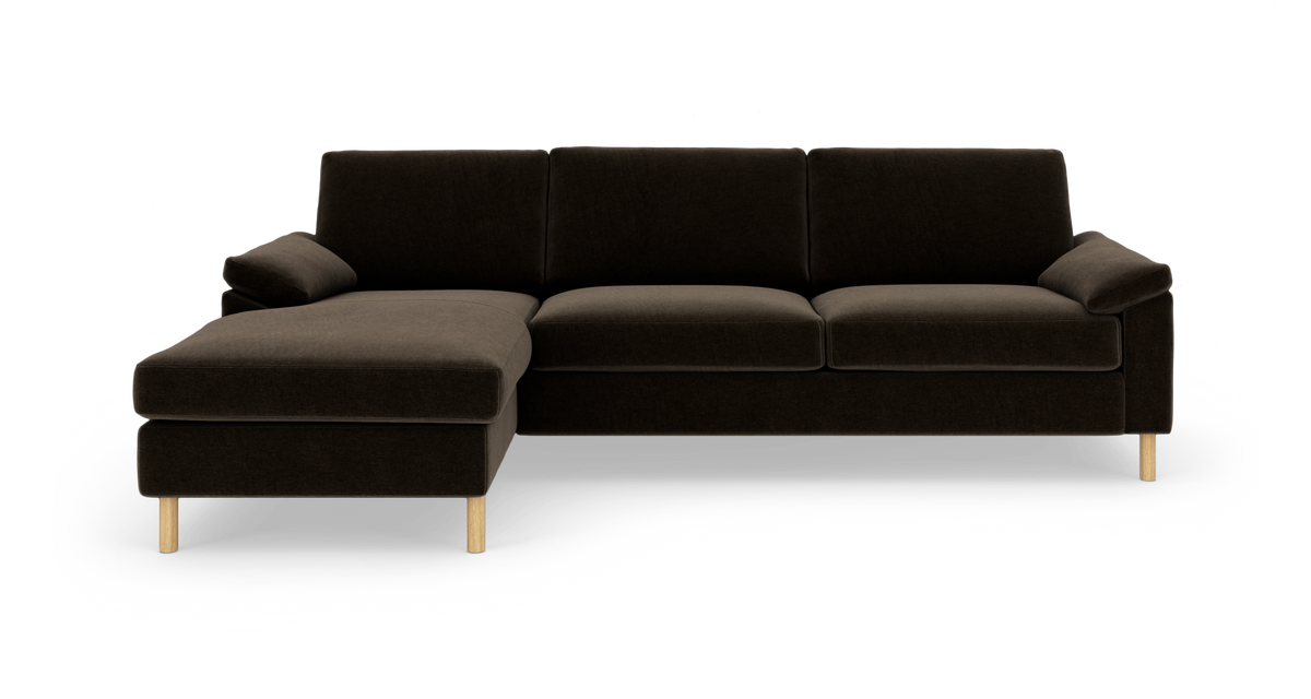 Mørkebrun hjørnesofa med venstrevendt chaiselong og lyse træben, frilagt på hvid baggrund.