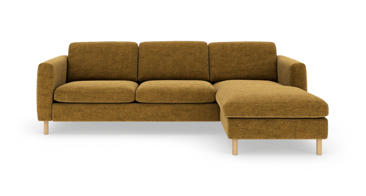 Sennepsgul hjørnesofa med chaiselong til højre, fritlagt.