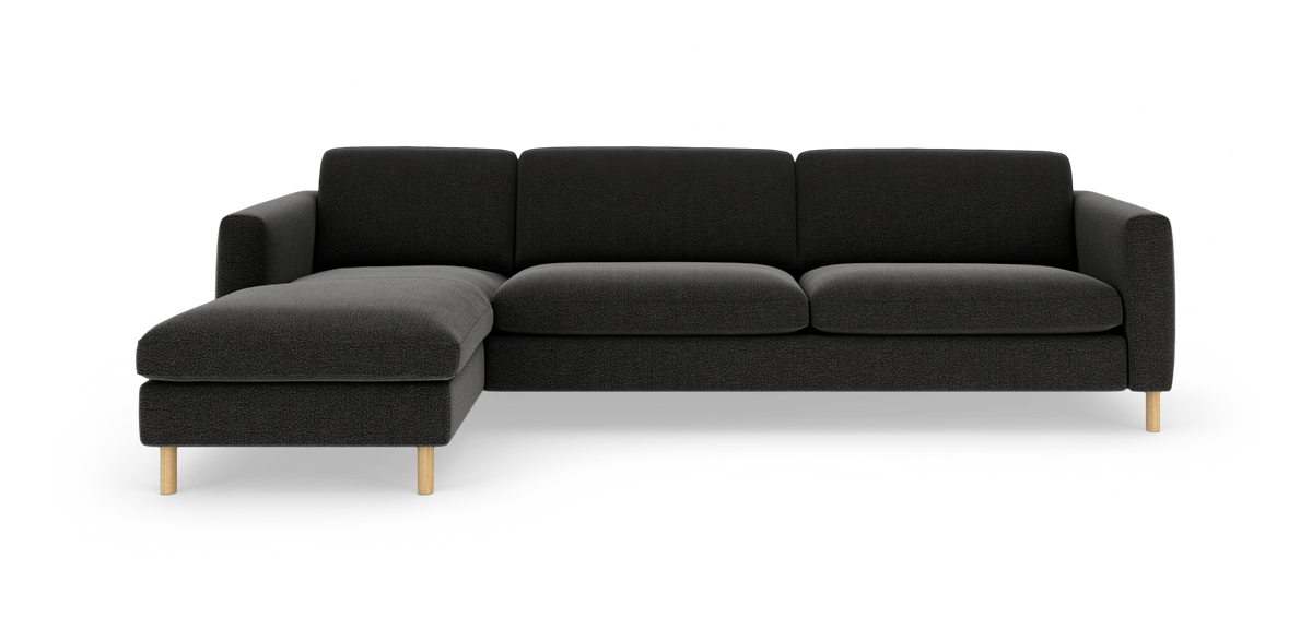 Mørkegrå 3-personers sofa med venstrevendt chaiselong og lyse træben, frilagt på hvid baggrund.