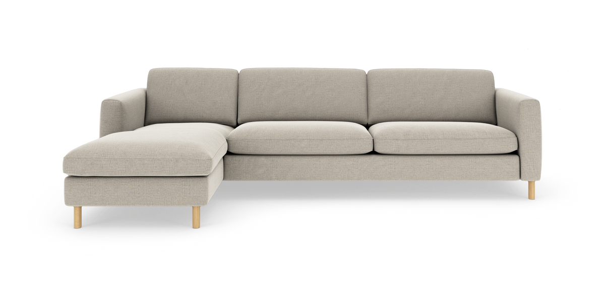 Beige stofsofa med venstre chaiselong og runde træben, fotograferet forfra på hvid baggrund.