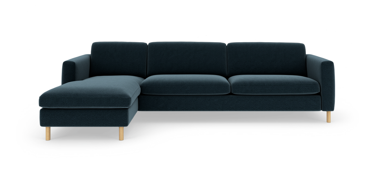 Mørkeblå modulsofa med venstrevendt chaiselong og lyse træben, frilagt mod hvid baggrund.